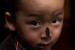 A boy's nose is marked with ash in a religious ceremony in Lhasa, Tibet.