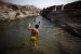 Swimmer wades into the waters at Hatta Pools, a wadi oasis in the desert of the United Arab Emirates.