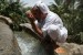 Sulem al Abri washes in the falaj before praying in the mosque in Misfat Oman